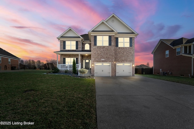 traditional-style home with brick siding, a front lawn, a porch, a garage, and driveway