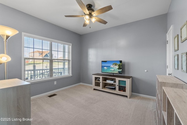 carpeted living area featuring visible vents, baseboards, and ceiling fan