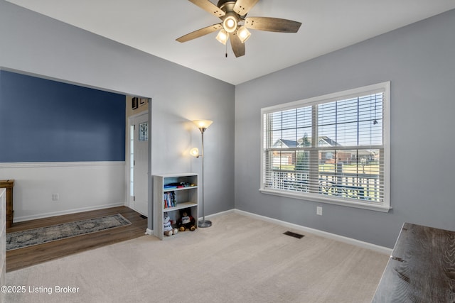 interior space featuring visible vents, baseboards, and a ceiling fan