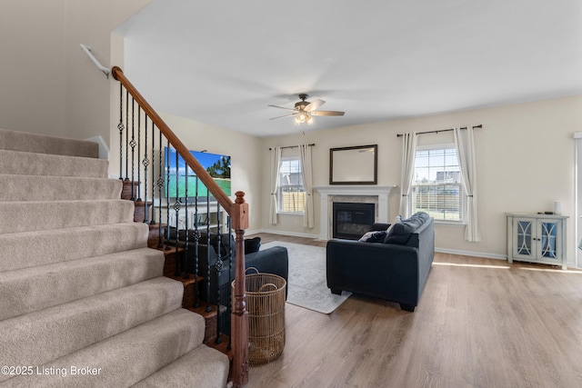 living room with baseboards, wood finished floors, ceiling fan, and stairs