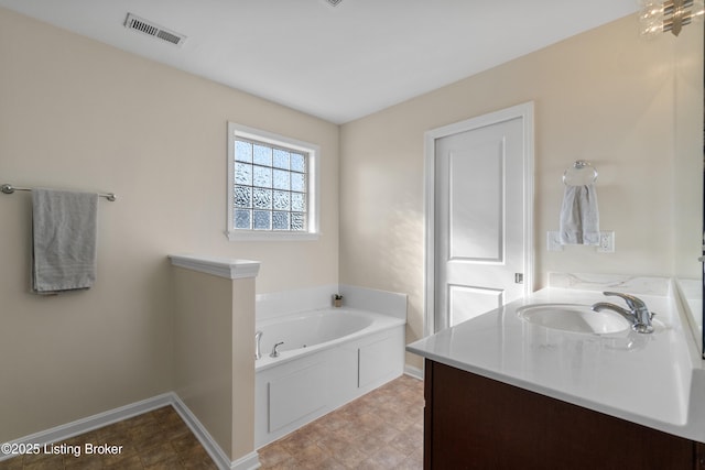 full bath featuring vanity, a garden tub, baseboards, and visible vents