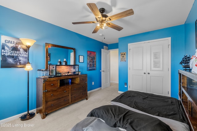 carpeted bedroom featuring a ceiling fan, baseboards, and a closet