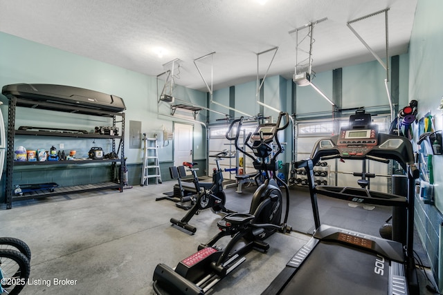 gym featuring electric panel and a textured ceiling