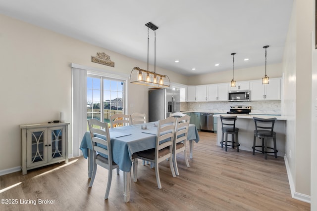 dining room with recessed lighting, baseboards, and light wood-style floors