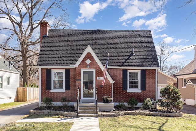 view of front of house with brick siding, a shingled roof, a chimney, and fence