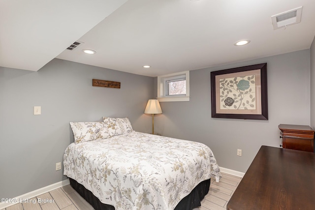 bedroom featuring visible vents, baseboards, and wood finished floors