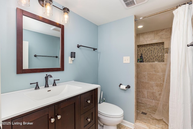 full bathroom featuring visible vents, tiled shower, toilet, and vanity