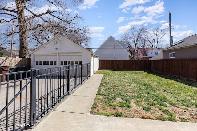 view of yard with a detached garage, a fenced backyard, and an outdoor structure