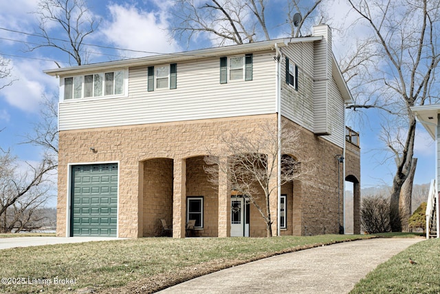 view of front of home with a garage, driveway, a front lawn, and a chimney