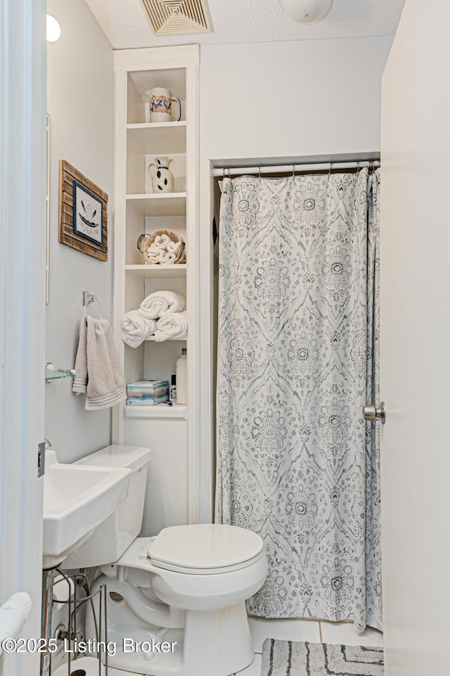 full bath with visible vents, toilet, and a shower with curtain