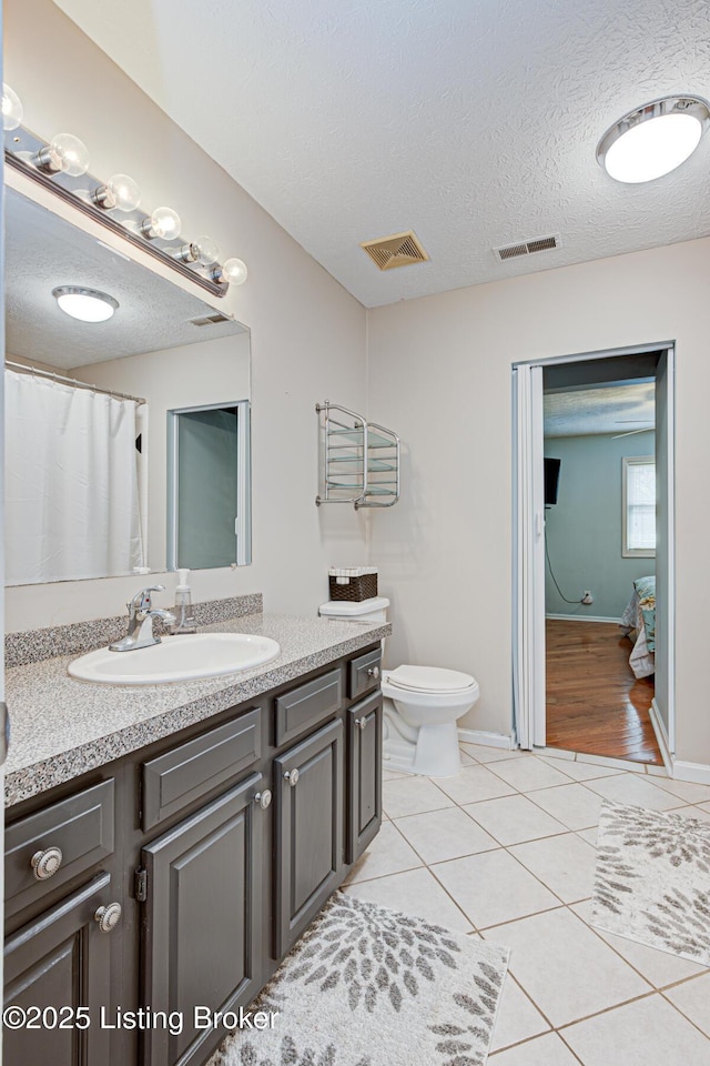 full bath with vanity, tile patterned floors, visible vents, and a textured ceiling