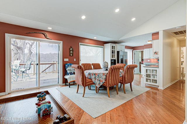 dining room featuring light wood-type flooring, visible vents, recessed lighting, baseboards, and lofted ceiling