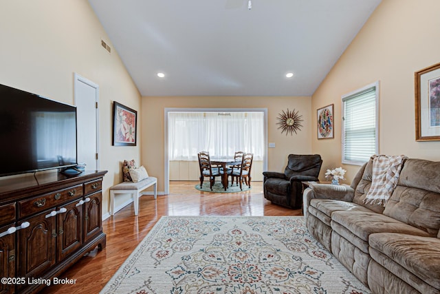 living area with visible vents, recessed lighting, high vaulted ceiling, and wood finished floors