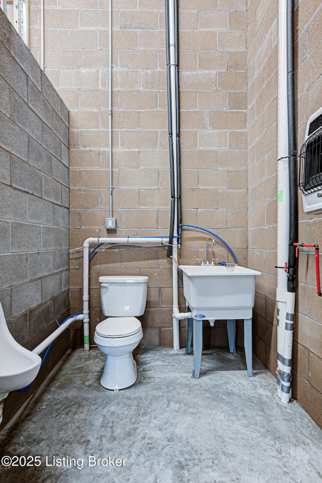 bathroom with toilet and unfinished concrete flooring