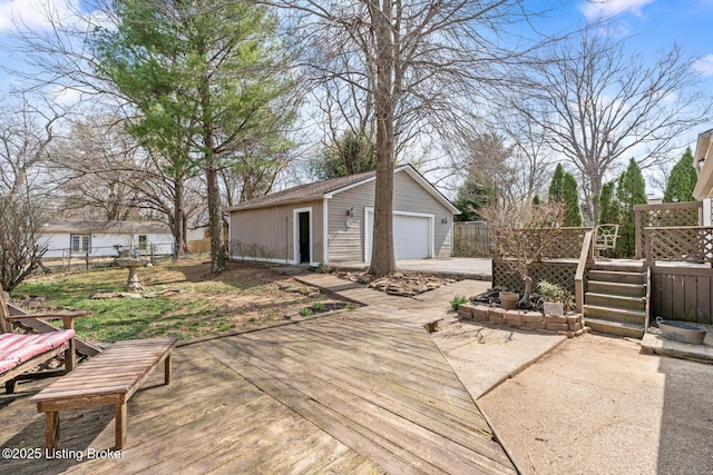 deck with an outbuilding, a detached garage, and fence