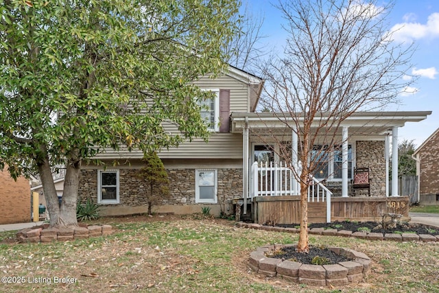 split level home with stone siding and a porch