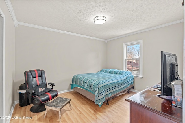 bedroom with baseboards, a textured ceiling, wood finished floors, and crown molding