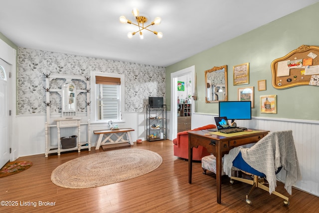 home office with an inviting chandelier, wood finished floors, and wainscoting