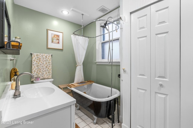 full bath with tile patterned flooring, visible vents, a closet, a soaking tub, and vanity