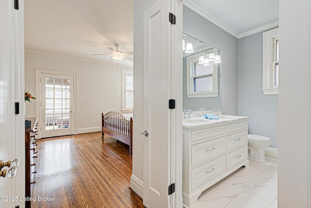 bathroom featuring baseboards, vanity, ornamental molding, and a ceiling fan