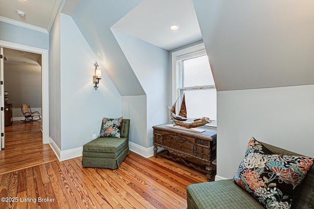 living area with light wood finished floors, lofted ceiling, and baseboards