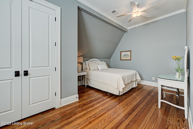 bedroom featuring visible vents, hardwood / wood-style flooring, crown molding, baseboards, and vaulted ceiling