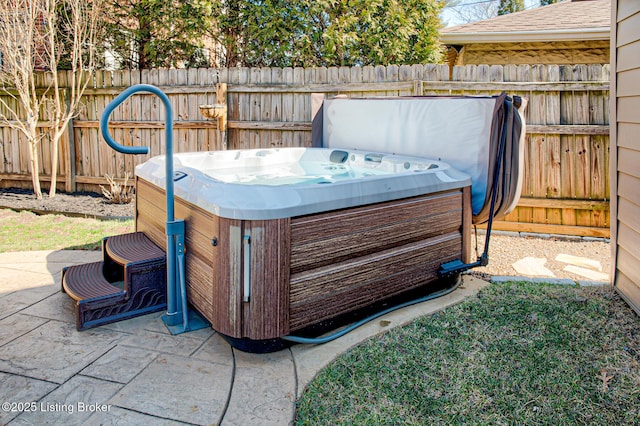 view of patio / terrace featuring a hot tub and fence