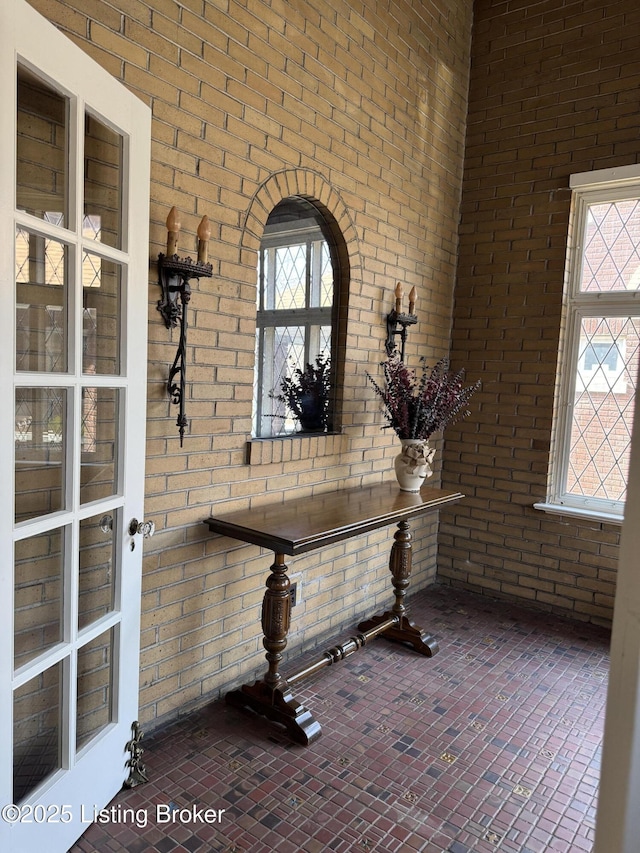 interior space with brick floor and brick wall