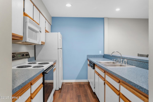 kitchen with a sink, dark wood-style floors, recessed lighting, white appliances, and white cabinets