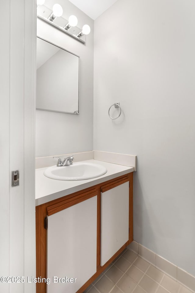 bathroom with baseboards, vanity, and tile patterned flooring