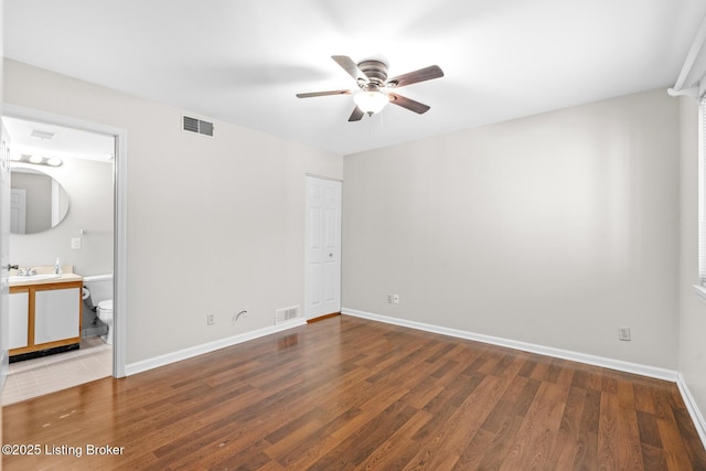 unfurnished bedroom featuring wood finished floors, visible vents, and baseboards