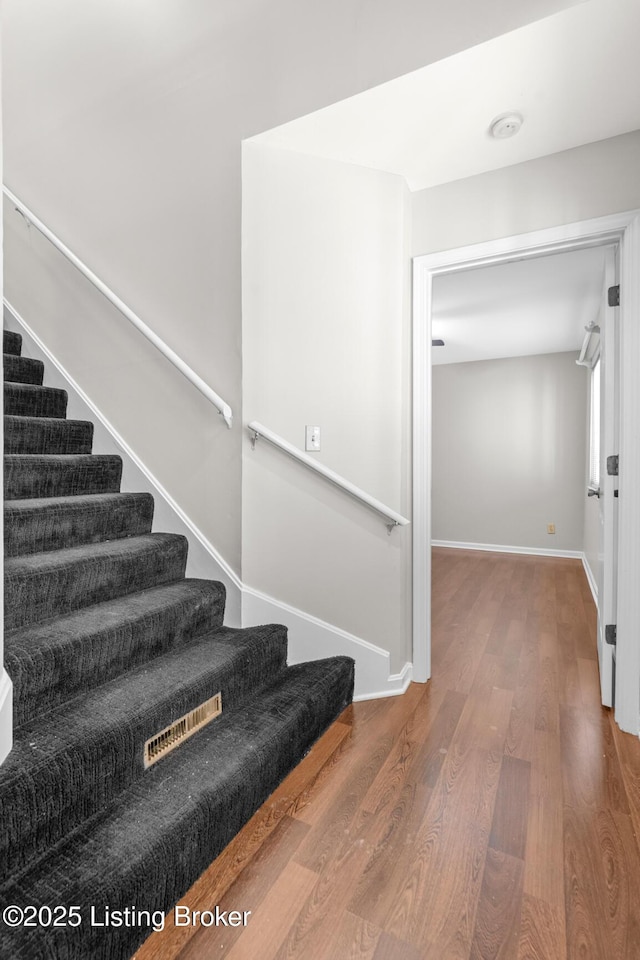 stairs featuring baseboards and wood finished floors