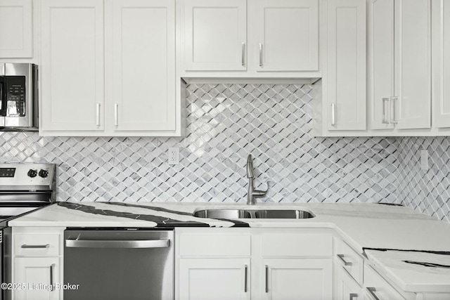 kitchen with a sink, stainless steel appliances, and white cabinetry