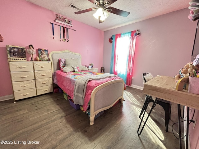 bedroom featuring visible vents, a textured ceiling, wood finished floors, baseboards, and ceiling fan