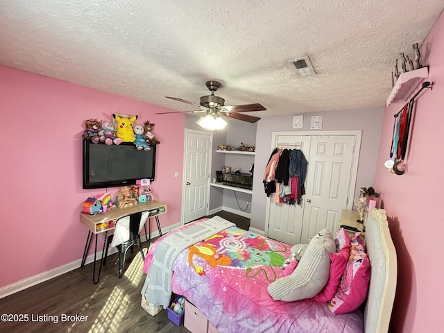 bedroom featuring wood finished floors, visible vents, a closet, and baseboards