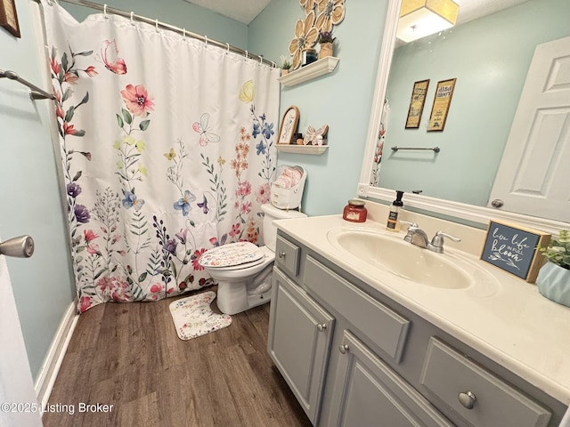 full bath featuring a shower with shower curtain, toilet, wood finished floors, and vanity