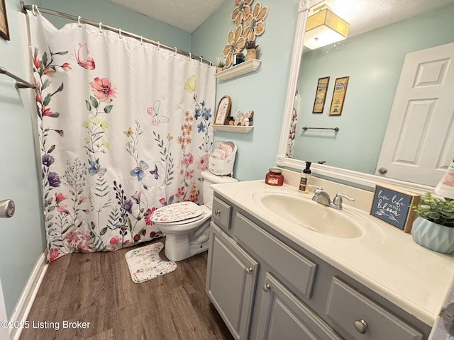 full bathroom with toilet, a shower with shower curtain, vanity, wood finished floors, and a textured ceiling