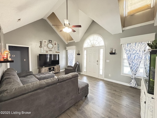 living room featuring a wealth of natural light, visible vents, dark wood-type flooring, and ceiling fan