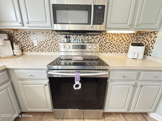 kitchen featuring white cabinetry, light countertops, backsplash, and stainless steel appliances