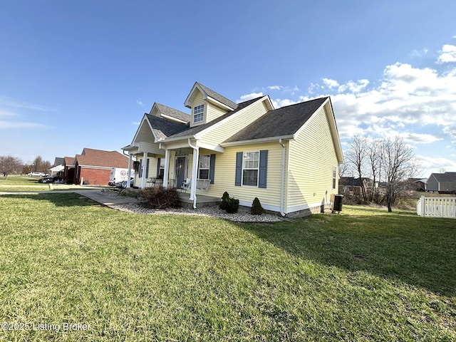 view of front of property featuring a front lawn, fence, central AC, and roof with shingles