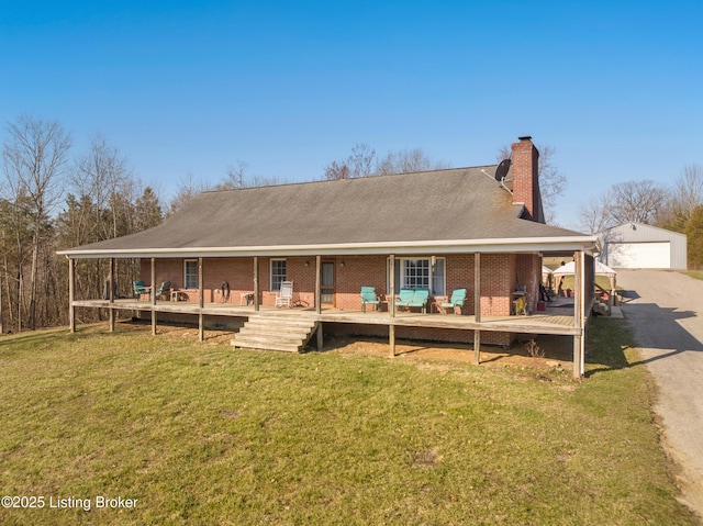 back of property featuring an outdoor structure, a yard, brick siding, and a chimney