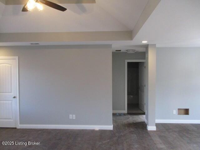 empty room with vaulted ceiling, a ceiling fan, and baseboards