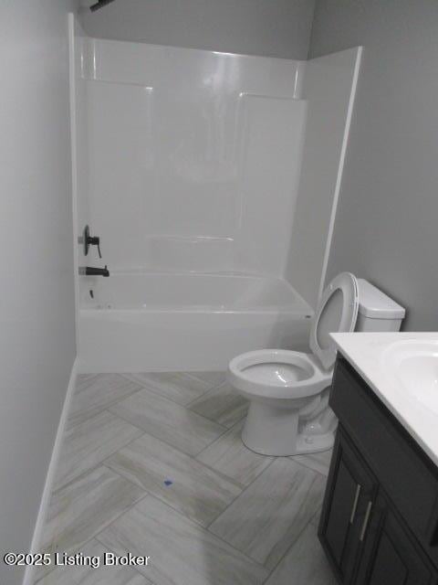 bathroom featuring vanity, toilet, baseboards, and shower / bathtub combination