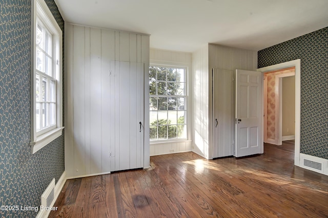 foyer entrance featuring plenty of natural light, wallpapered walls, and visible vents