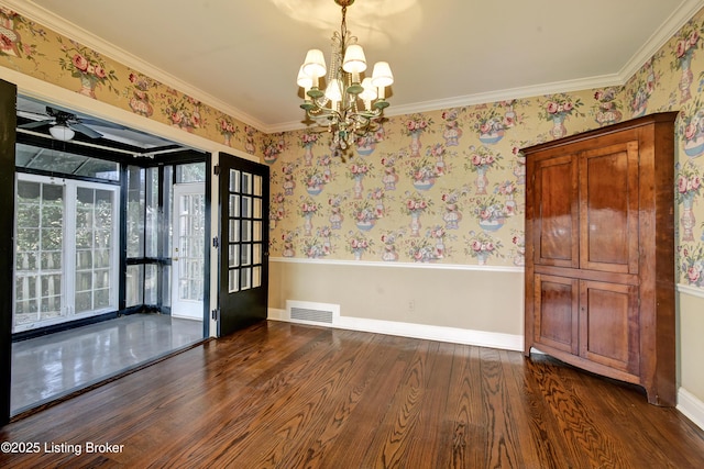 empty room featuring visible vents, baseboards, dark wood finished floors, and wallpapered walls