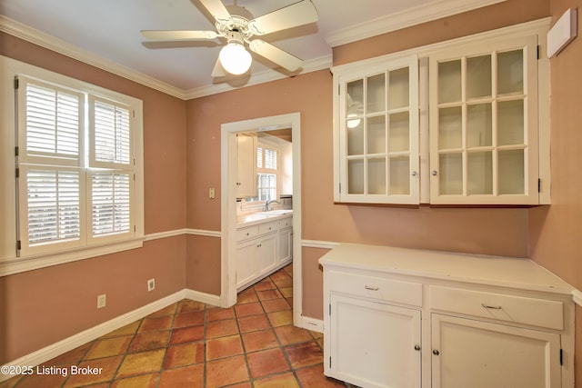 kitchen with a wealth of natural light, ornamental molding, and a sink