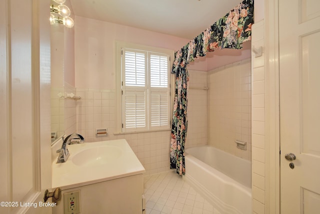 bathroom featuring vanity, a wainscoted wall, tile patterned flooring, shower / bath combination with curtain, and tile walls