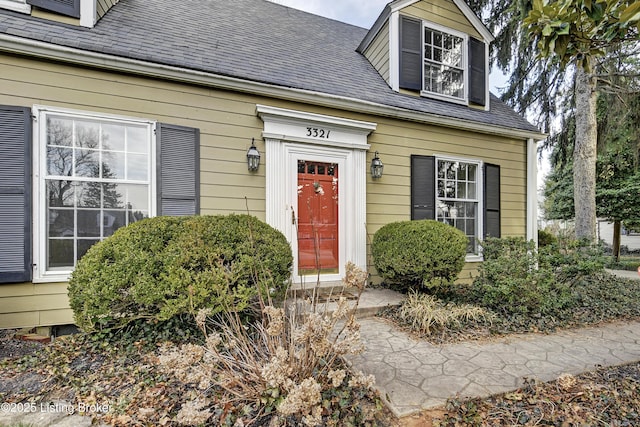 doorway to property with a shingled roof