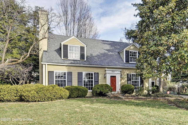 cape cod-style house featuring a chimney, a front yard, and a shingled roof