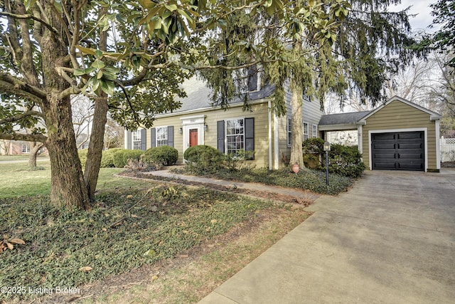 view of front facade featuring concrete driveway, a garage, and roof with shingles